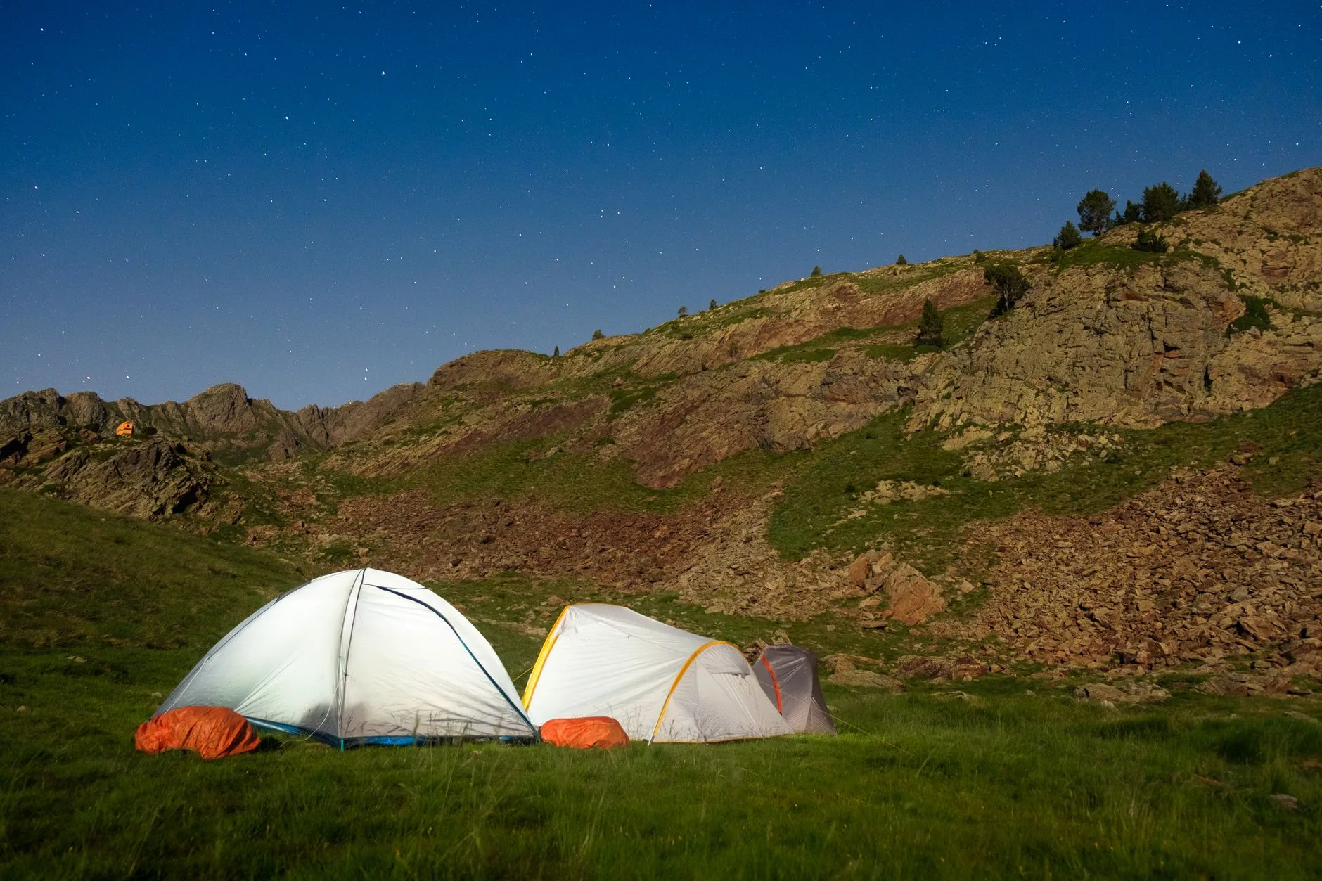 Tentes de randonnée sous un ciel étoilé en montagne